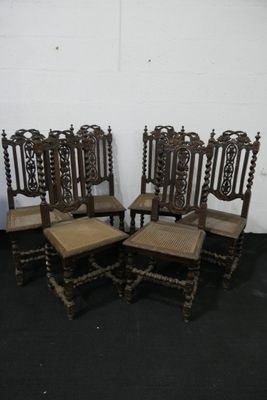quatre chaises anciennes en bois avec des dossiers en rotin