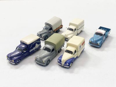 plusieurs petites voitures sont alignées sur une surface blanche