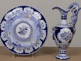 two blue and white plates and a vase on a table