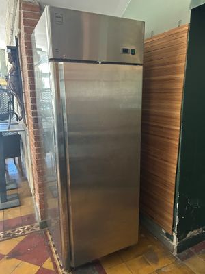 a silver refrigerator in the corner of a room