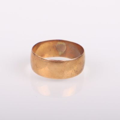gros plan d'une bague en or sur une surface blanche