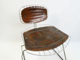une chaise en métal avec une assise en cuir, sur fond blanc