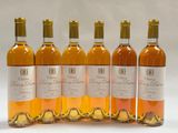 quatre bouteilles de vin sont alignées sur une surface blanche