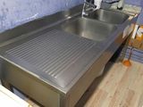 a stainless steel sink in the corner of a kitchen