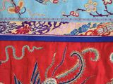 a close up of a red and blue cloth with a bird on it