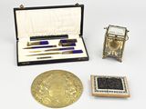 une petite boîte contenant un stylo, un encrier et d'autres objets, posée sur une table