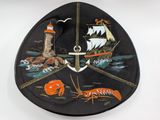 a black plate with a picture of a boat and a lighthouse
