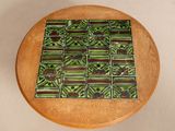 a wooden table with a green and brown tile on it