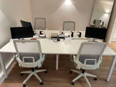 deux bureaux équipés d'ordinateurs dans une petite pièce