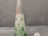 a green glass vase sitting next to a pair of scissors