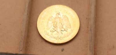 une pièce d'or posée sur une boîte marron