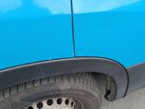 a close up of a blue car with holes in the tire