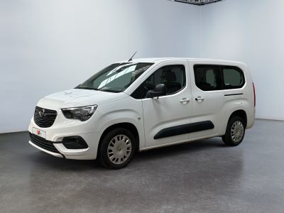 La camionnette blanche est garée dans une grande pièce blanche.