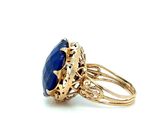 an image of a gold ring with a blue stone in it