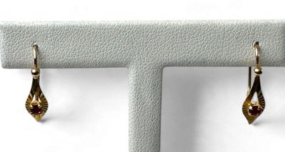 deux paires de boucles d'oreilles en or exposées sur un fond blanc