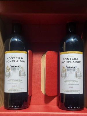 two bottles of wine sitting in a box on a table