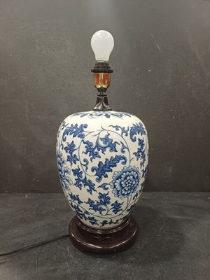blue and white vase with a light bulb on top of it
