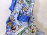 a figurine of a woman sitting on a table