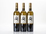 three bottles of white wine sitting next to each other on a table