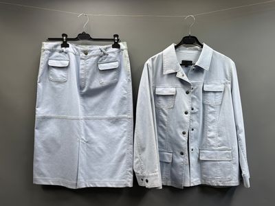 deux chemises blanches suspendues à un portant devant un mur gris