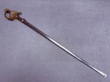 gros plan d'une épée avec un manche sur une surface grise