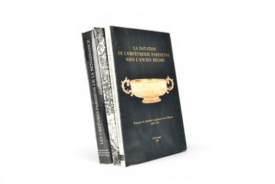 le livre est posé sur une surface blanche, à côté d'un livre noir