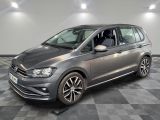une Volkswagen Touran grise garée sur un sol à damier