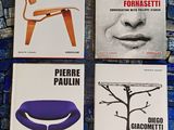 quatre livres posés sur un sol carrelé bleu, avec une chaise et une table