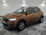 Une voiture marron est garée dans une pièce au sol à carreaux.