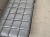 un banc en cuir noir situé dans un coin de la pièce