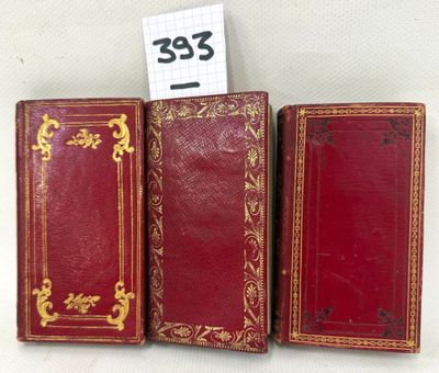 three red leather books with gold trims and gold trim