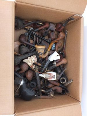 une boîte en carton remplie d'une sélection de pipes et d'autres objets