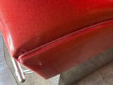 a close up of a red leather chair on a tile floor