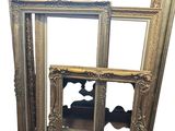 une image représentant un cadre photo doré posé sur un mur blanc