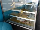 a blue chair in front of a glass display case
