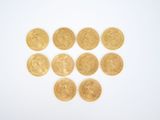 a close up of a bunch of gold coins on a white surface