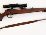 un fusil posé sur une surface blanche
