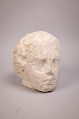 white sculpture of a head on a gray surface