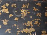 a black suitcase with gold flowers and leaves on it