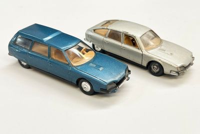 deux voitures jouets assises l'une à côté de l'autre sur une surface blanche