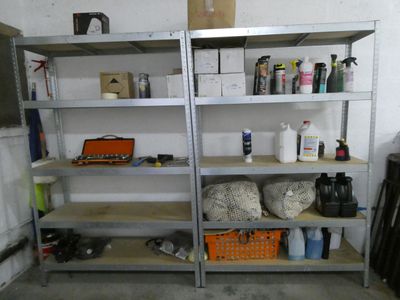 a metal shelving with many items on it in a garage