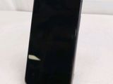 a black cell phone sitting on a stand on a table