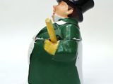 a figurine of a man in a top hat and coat holding a banana