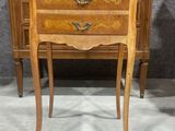 une petite commode en bois exposée dans une pièce