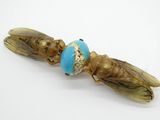 un petit insecte avec une perle bleue sur le dos