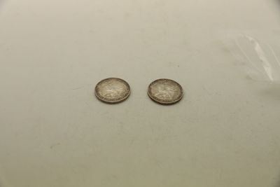deux pièces d'argent posées sur une assiette blanche