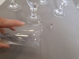 a person that is holding a clear glass on a table
