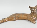 une image représentant une figurine de chat posée sur une surface blanche