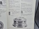 an open book with a picture of a silver object on it