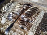 many spoons and forks in a box on a table